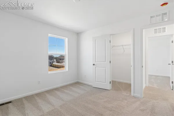 a view of an empty room with window and closet