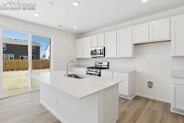a kitchen with sink a microwave and cabinets