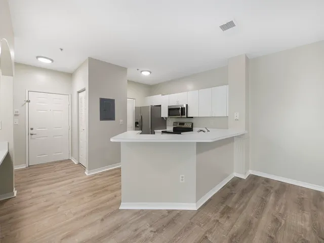 a view of kitchen with stainless steel appliances refrigerator stove microwave and cabinets