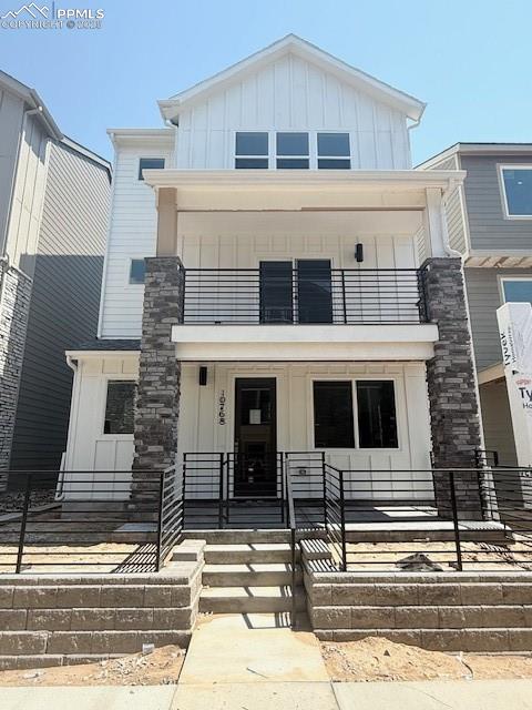 View of front of home featuring a balcony, board and batten siding, and a porch