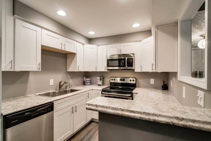 500 Paragon Mills Road, Unit N7 Nashville, TN 37211 - Photo 4 of 21 a kitchen with stainless steel appliances granite countertop white cabinets a stove a sink and a microwave