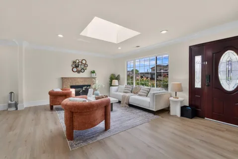 a living room with furniture a fireplace and a large window