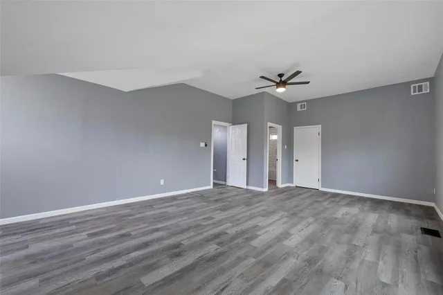 a view of an empty room with a ceiling fan and a window
