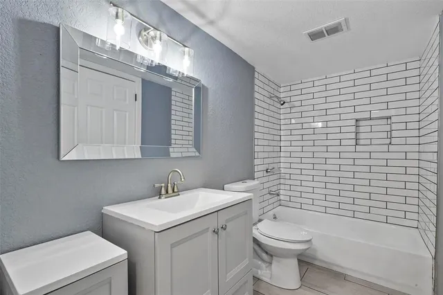 a bathroom with a toilet a sink a mirror and shower