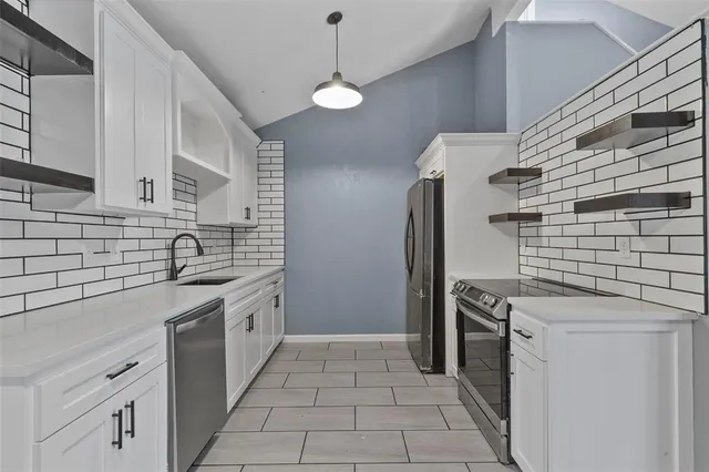 a kitchen with stainless steel appliances granite countertop a sink and a stove