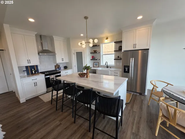 a large white kitchen with sink and refrigerator