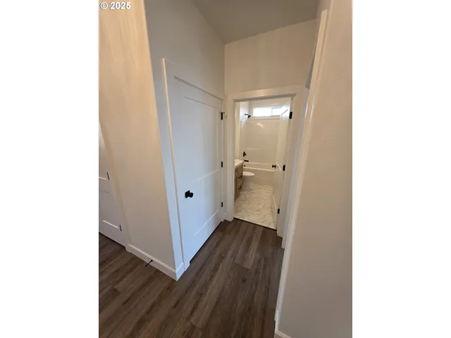 a view of a hallway with wooden floor