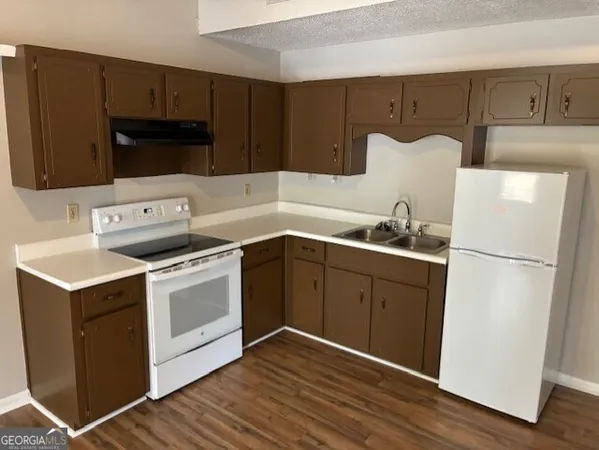 a kitchen with a refrigerator sink and cabinets