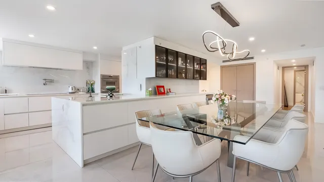 a kitchen with a dining table a sink and cabinets