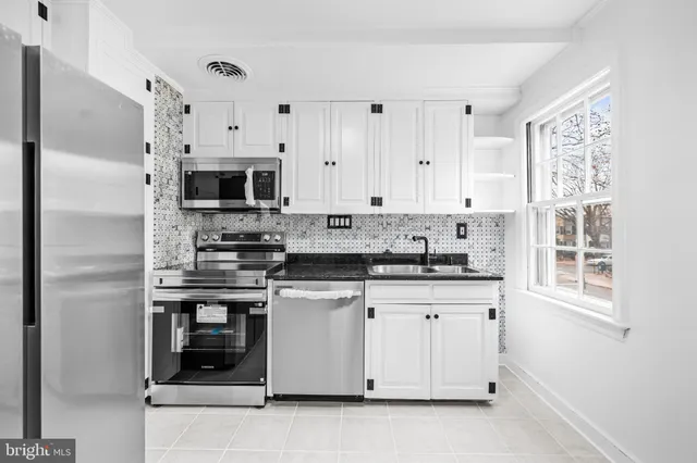 a kitchen with stainless steel appliances granite countertop a refrigerator and a stove top oven