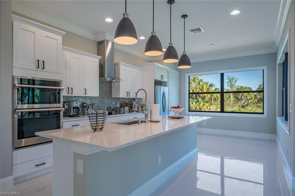 522 19th Street Northwest Naples, FL 34120 - Photo 11 of 33 a kitchen with stainless steel appliances granite countertop a sink a stove and a wooden floors