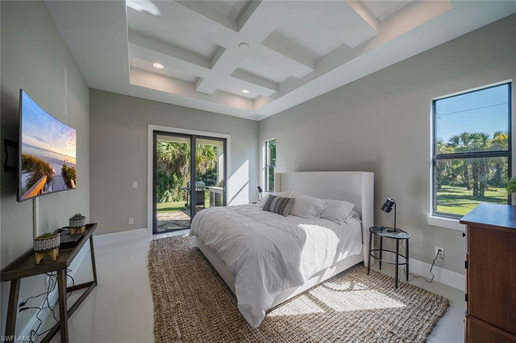 522 19th Street Northwest Naples, FL 34120 - Photo 22 of 33 a bedroom with a bed a couch and a window