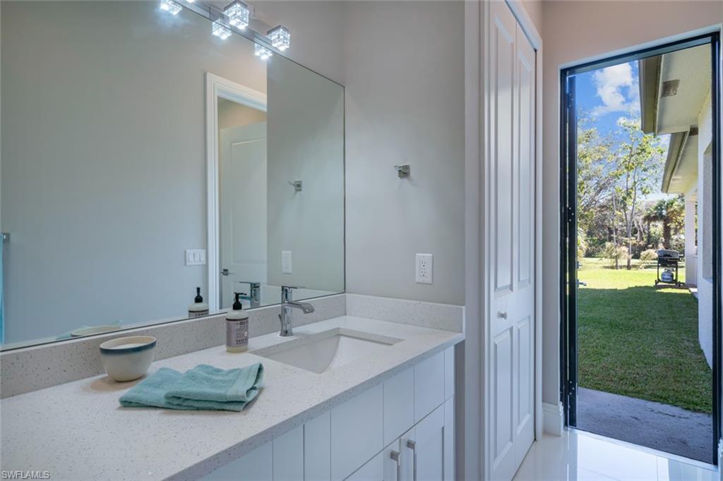 522 19th Street Northwest Naples, FL 34120 - Photo 26 of 33 a bathroom with a granite countertop sink and a mirror