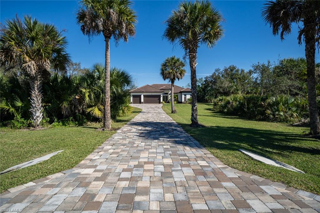 522 19th Street Northwest Naples, FL 34120 - Photo 3 of 33 a front view of a house with garden