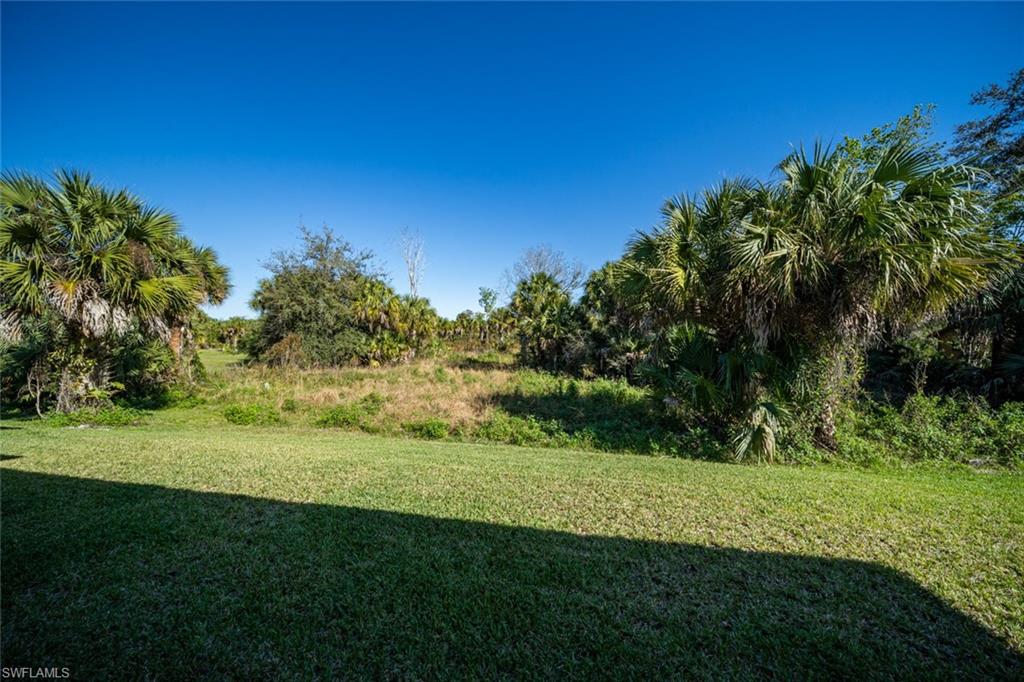522 19th Street Northwest Naples, FL 34120 - Photo 32 of 33 a view of a grassy field with trees