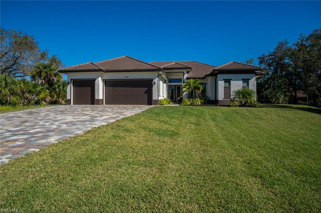 522 19th Street Northwest Naples, FL 34120 - Photo 5 of 33 a front view of a house with a yard and garage