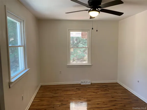 a kitchen with stainless steel appliances a stove a refrigerator a sink a dining table and chairs with wooden floor