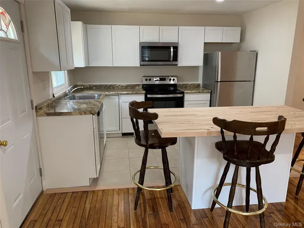 a kitchen with a wooden floor and a refrigerator