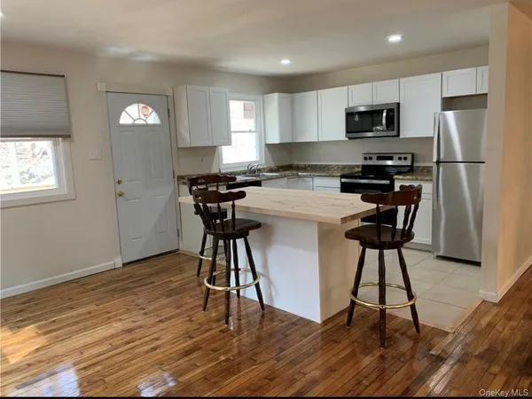 a kitchen with a stove a sink a microwave a refrigerator and cabinets