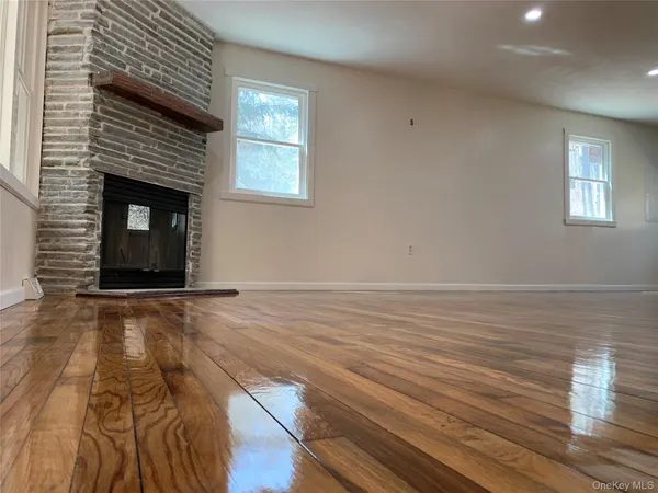 an empty room with wooden floor and fireplace