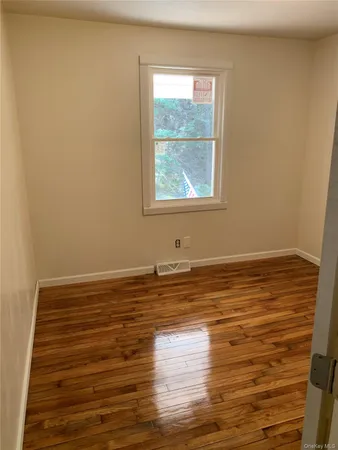 a view of a room with wooden floor and window