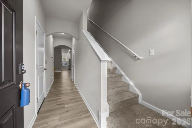 a view of a hallway with wooden floor and staircase