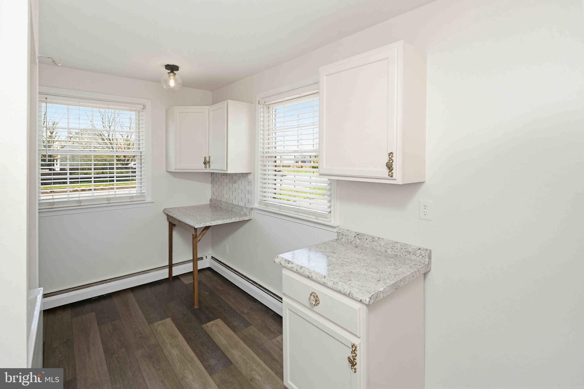 403 South Main Street, Unit S200 Doylestown, PA 18901 - Photo 14 of 26 a kitchen with granite countertop white cabinets and a wooden floor