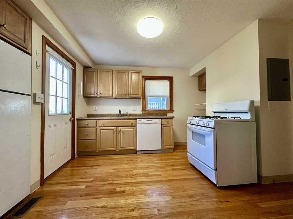 5 Rifle Court, Unit 5 Watertown, MA 02472 - Photo 14 of 14 a kitchen with stainless steel appliances granite countertop a stove a sink and a refrigerator