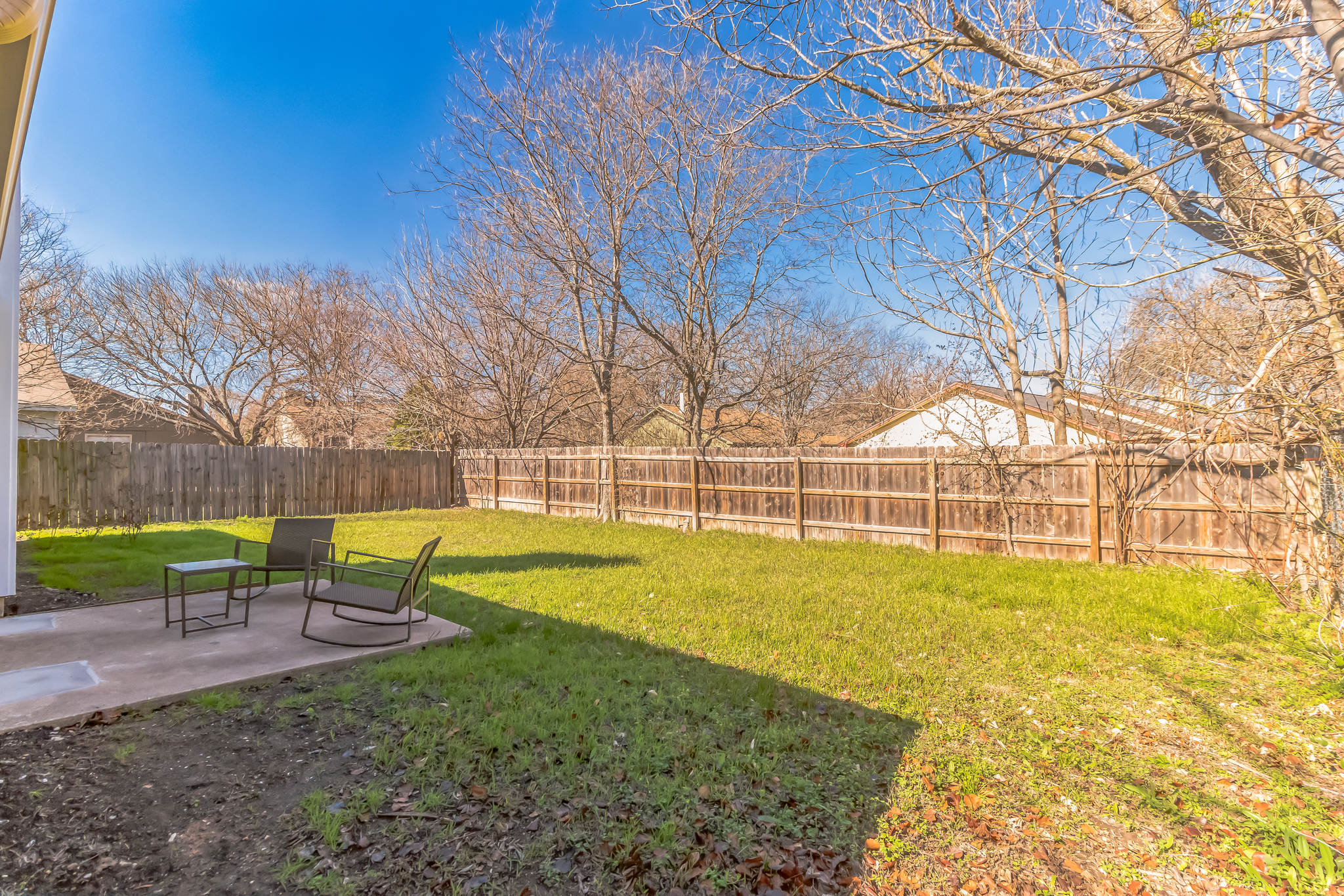 11406 Ruffed Grouse Drive Austin, TX 78758 - Photo 20 of 22 Mature trees frame a spacious, fully fenced lawn perfect for outdoor relaxation.
