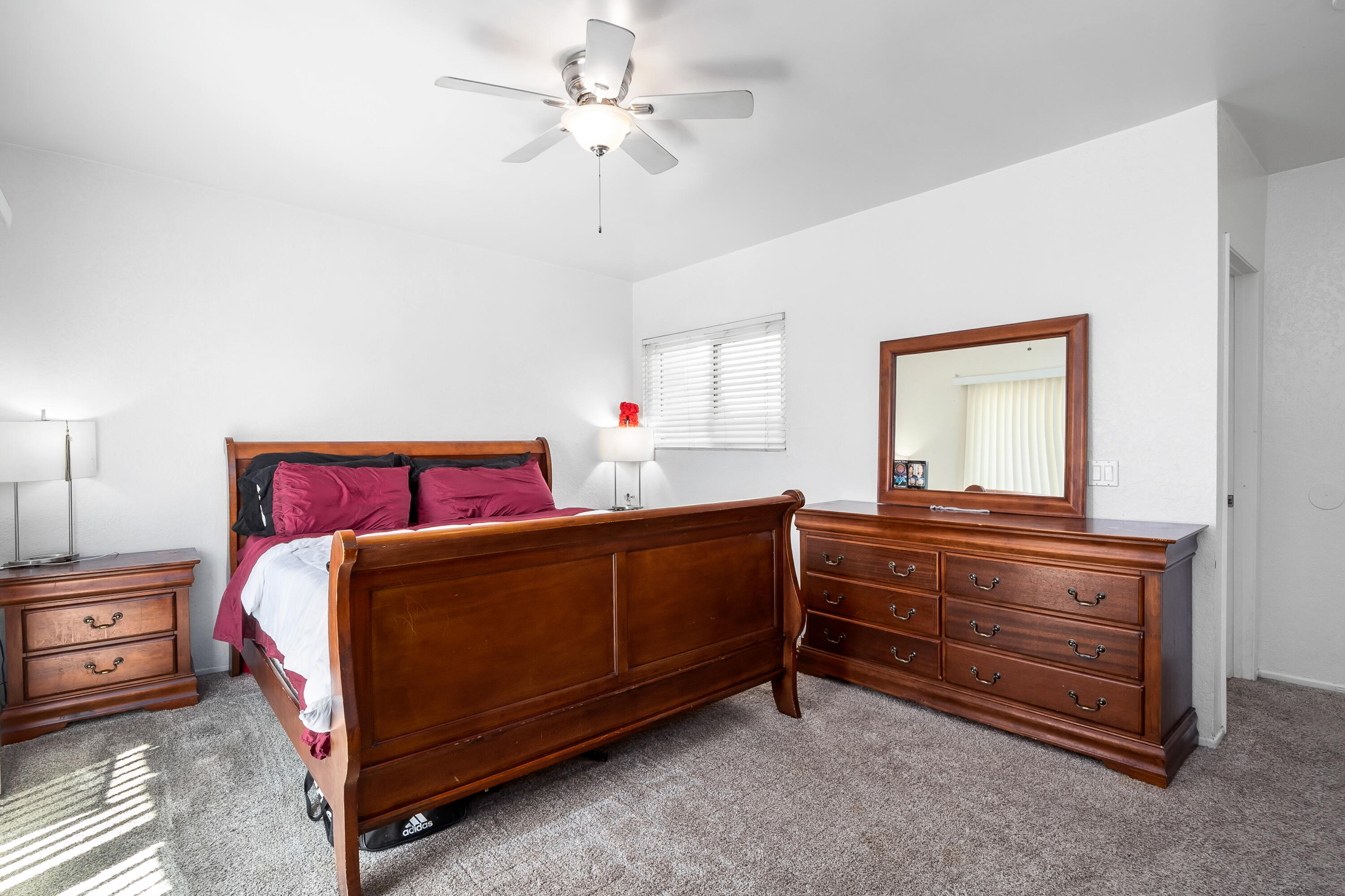 44200 Kingtree Avenue, Unit 24 Lancaster, CA 93534 - Photo 17 of 23 a bedroom with a bed and a chandelier