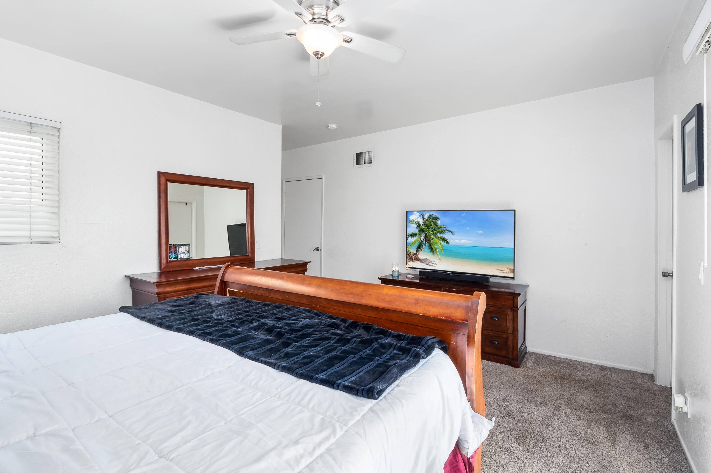 44200 Kingtree Avenue, Unit 24 Lancaster, CA 93534 - Photo 18 of 23 a bedroom with a bed and a chandelier