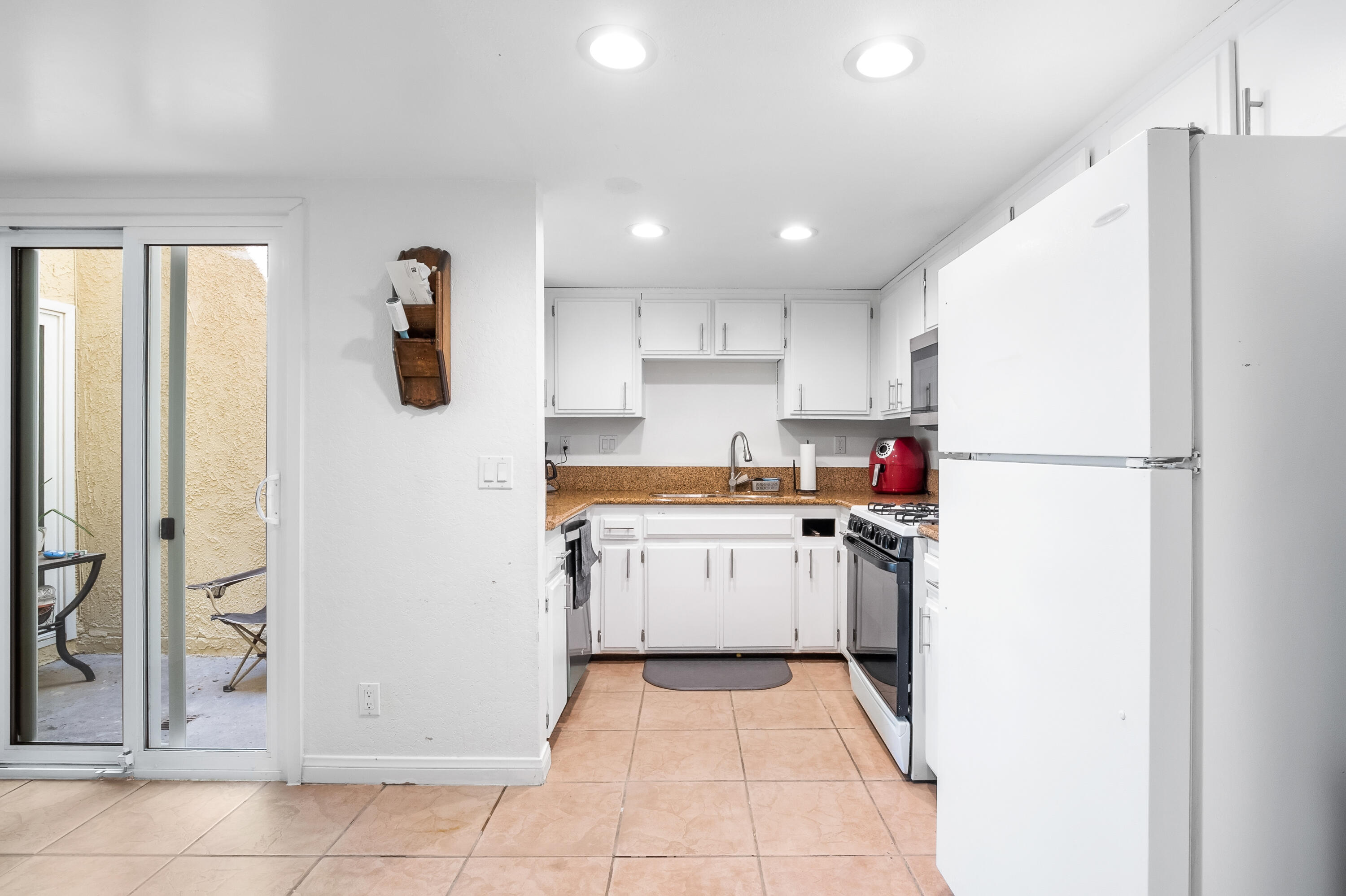 44200 Kingtree Avenue, Unit 24 Lancaster, CA 93534 - Photo 9 of 23 a kitchen with a refrigerator and a stove top oven