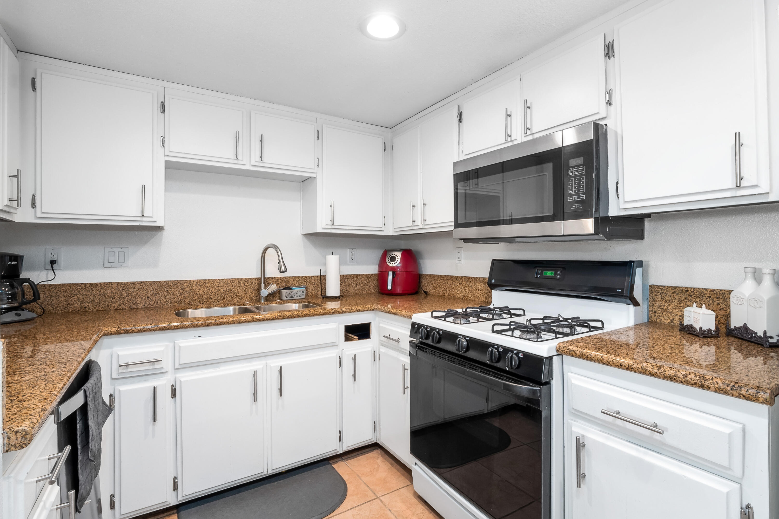 44200 Kingtree Avenue, Unit 24 Lancaster, CA 93534 - Photo 10 of 23 a kitchen with cabinets appliances a sink and a counter space