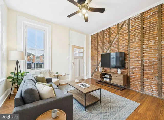 a living room with furniture tv and wooden floor
