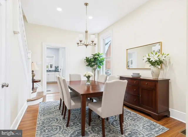 a dining room with furniture potted plants and wooden floor