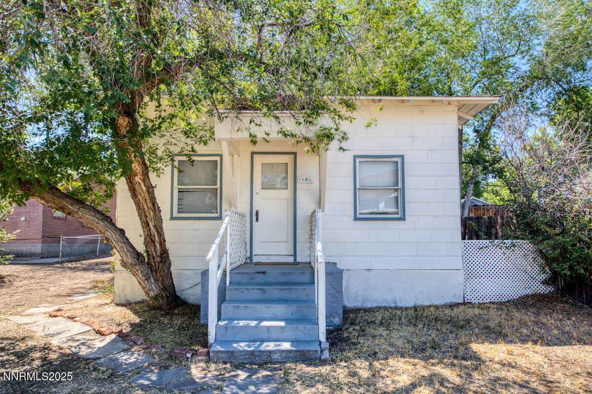 a front view of a house with a tree