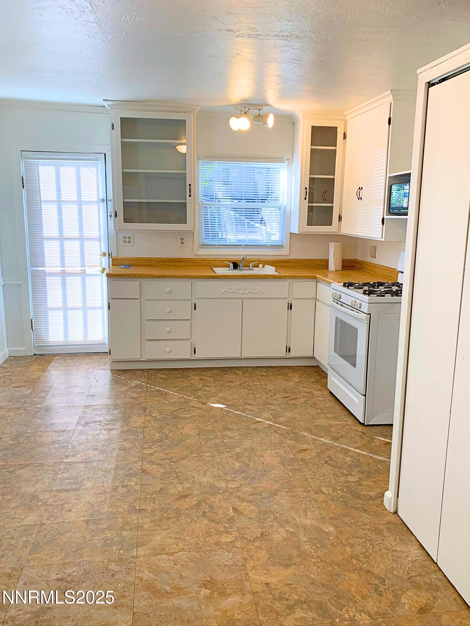 1151 Seminary Avenue Reno, NV 89503 - Photo 7 of 12 a kitchen with granite countertop a stove a sink and a refrigerator