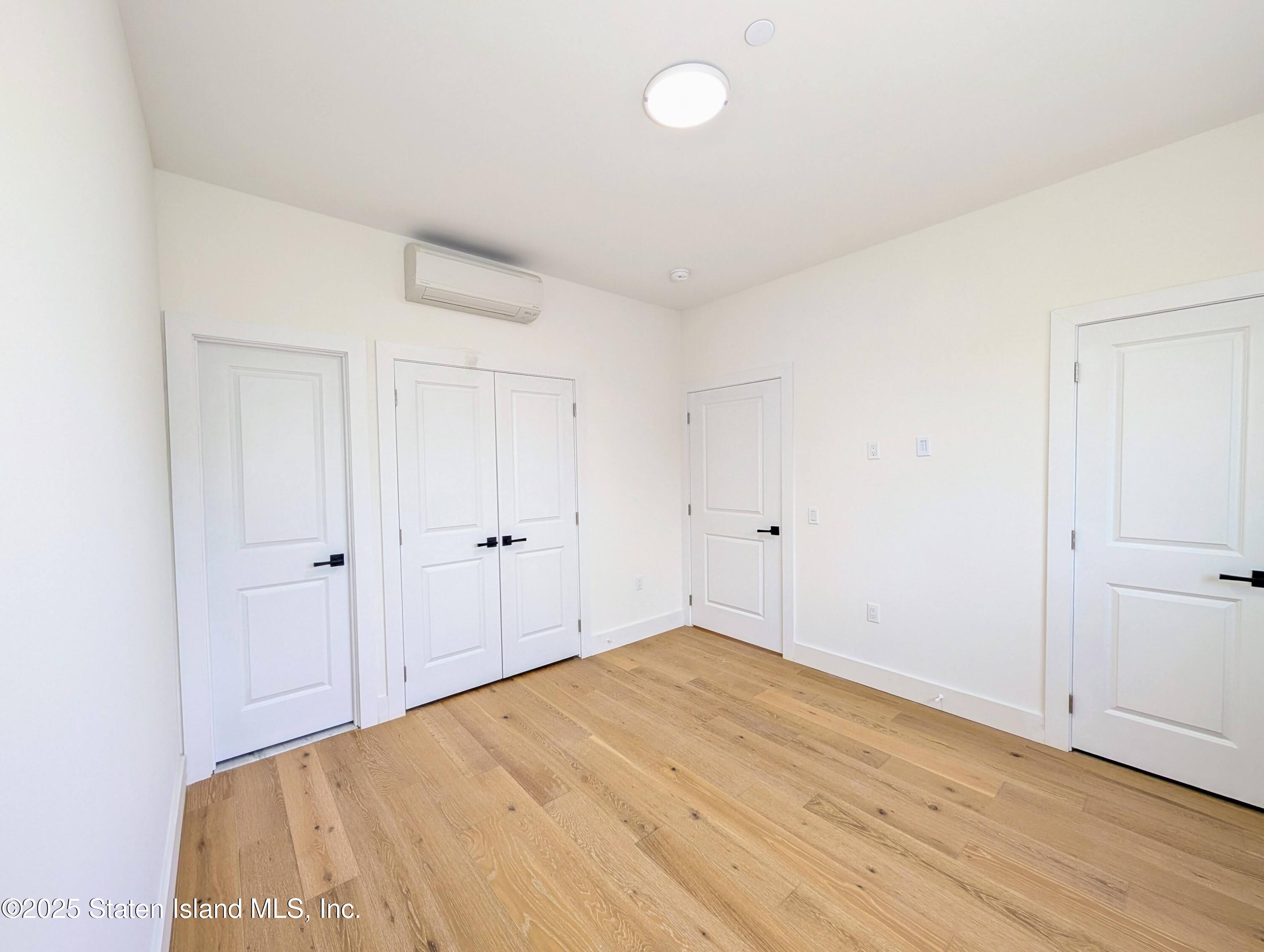 3865 Amboy Road, Unit 4B Staten Island, NY 10308 - Photo 11 of 20 a view of a room with wooden floor and white doors