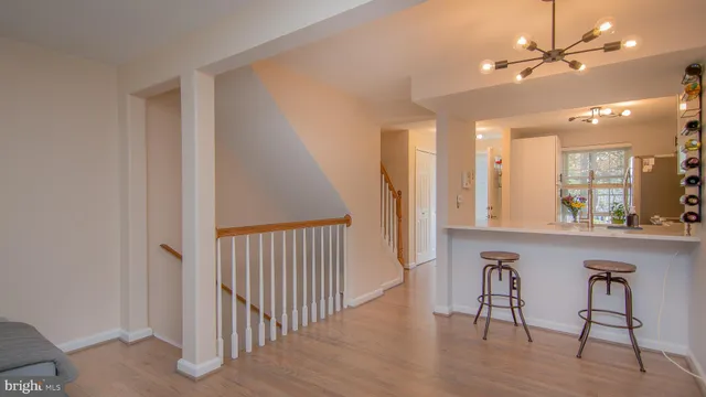 a view of a hallway with a dining table chairs and chandelier