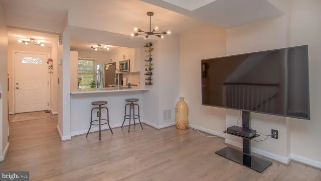 a kitchen with stainless steel appliances a kitchen island hardwood floor and a sink