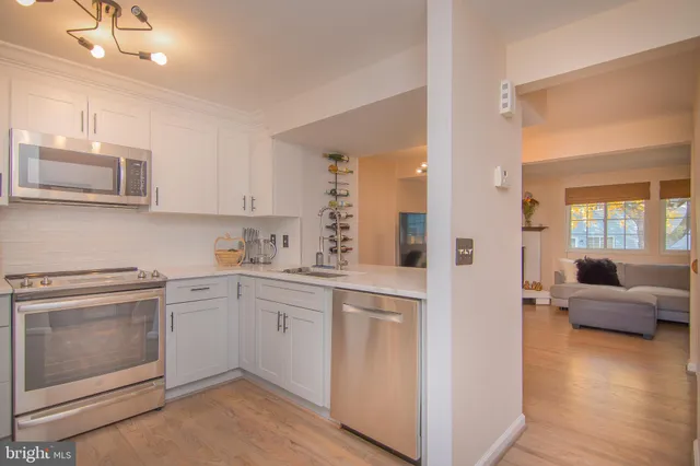 a kitchen with white cabinets and sink