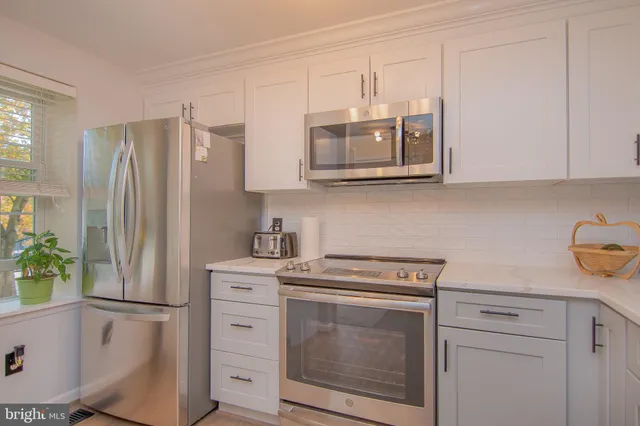 a kitchen with cabinets stainless steel appliances and a counter space