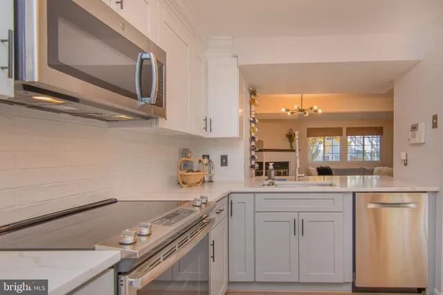 a kitchen with white cabinets and appliances