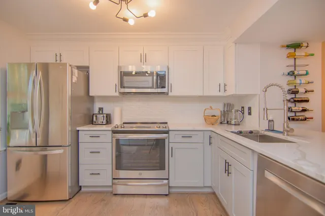 a kitchen with cabinets appliances and a sink