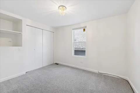 a view of a room with wooden floor and a window