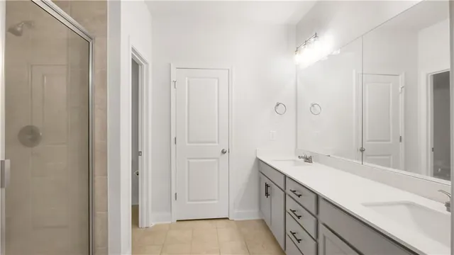 a spacious bathroom with a double vanity sink a mirror and a shower