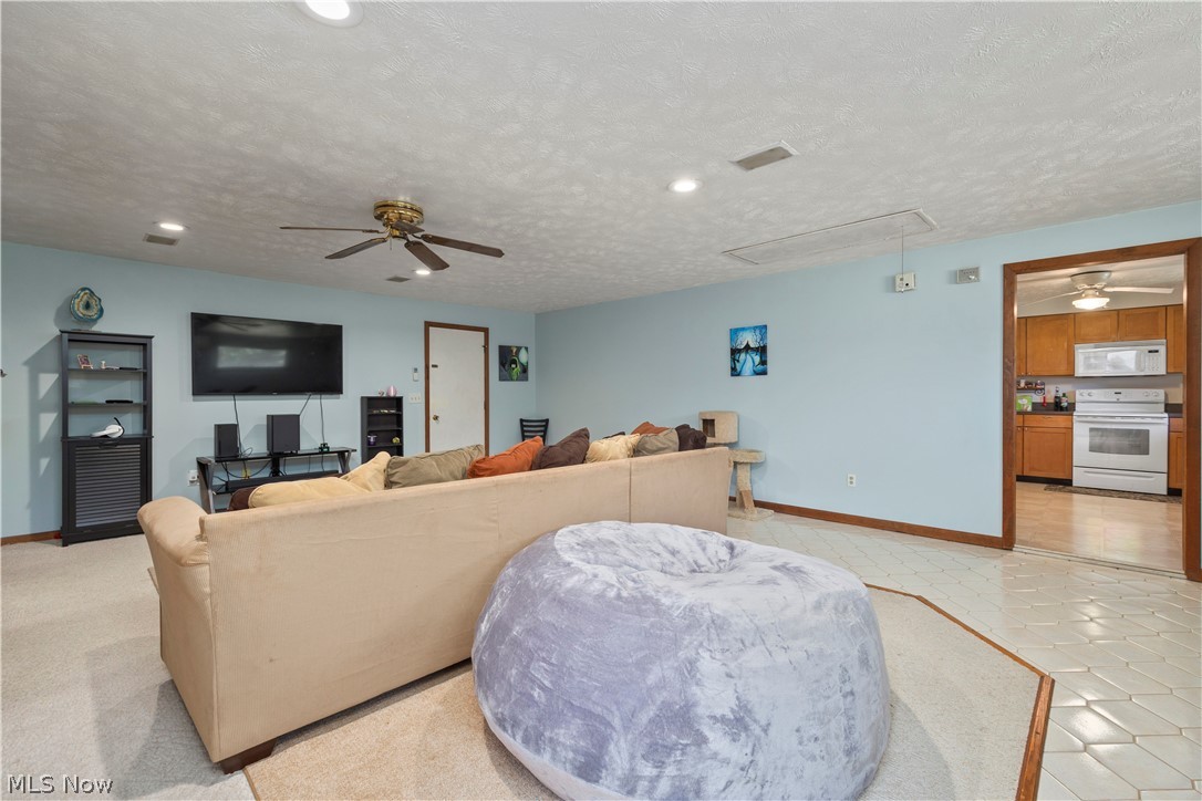 2565 Abbe Road North Sheffield Lake, OH 44054 - Photo 11 of 32 Family room with attic access, ceiling fan, recessed lighting, and light tile patterned floors