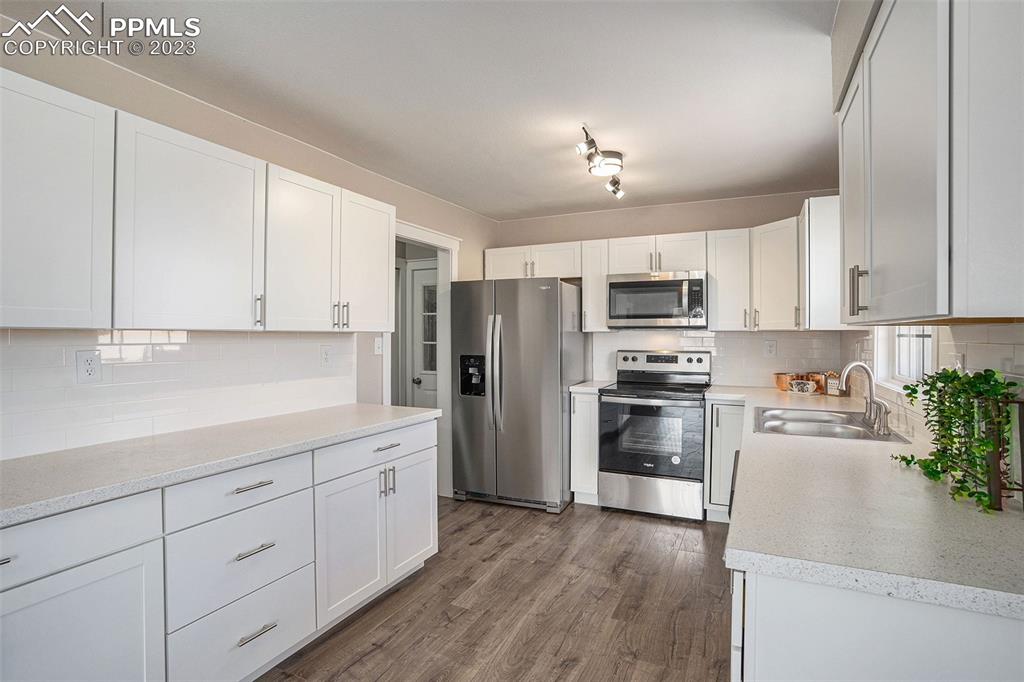 11615 Oil Well Road Calhan, CO 80808 - Photo 12 of 37 a kitchen with granite countertop white cabinets and stainless steel appliances