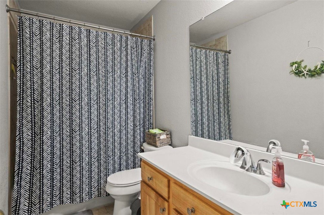 512 South Mockingbird Lane Lockhart, TX 78644 - Photo 18 of 22 a bathroom with a sink a toilet and shower curtain