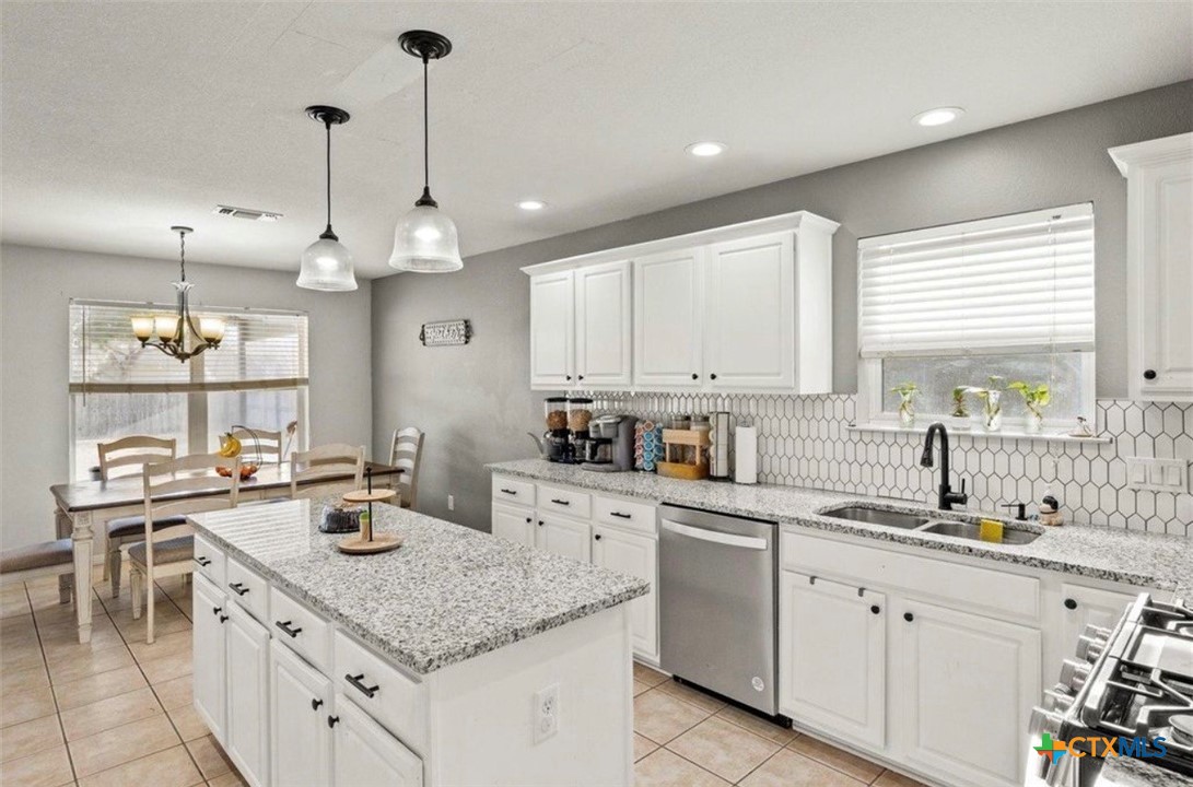 512 South Mockingbird Lane Lockhart, TX 78644 - Photo 6 of 22 a kitchen with a sink dishwasher and white cabinets with wooden floor